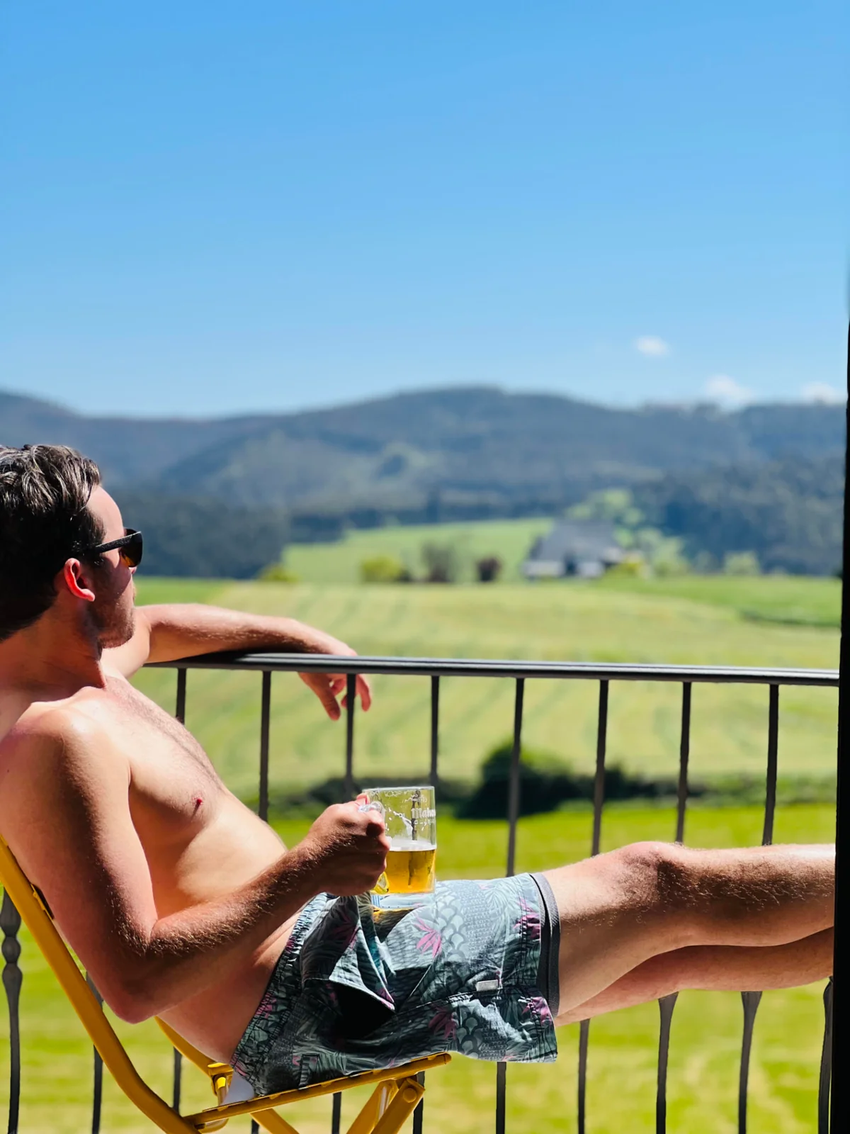 Danny in Guemes enjoying a beer with green hills in the background