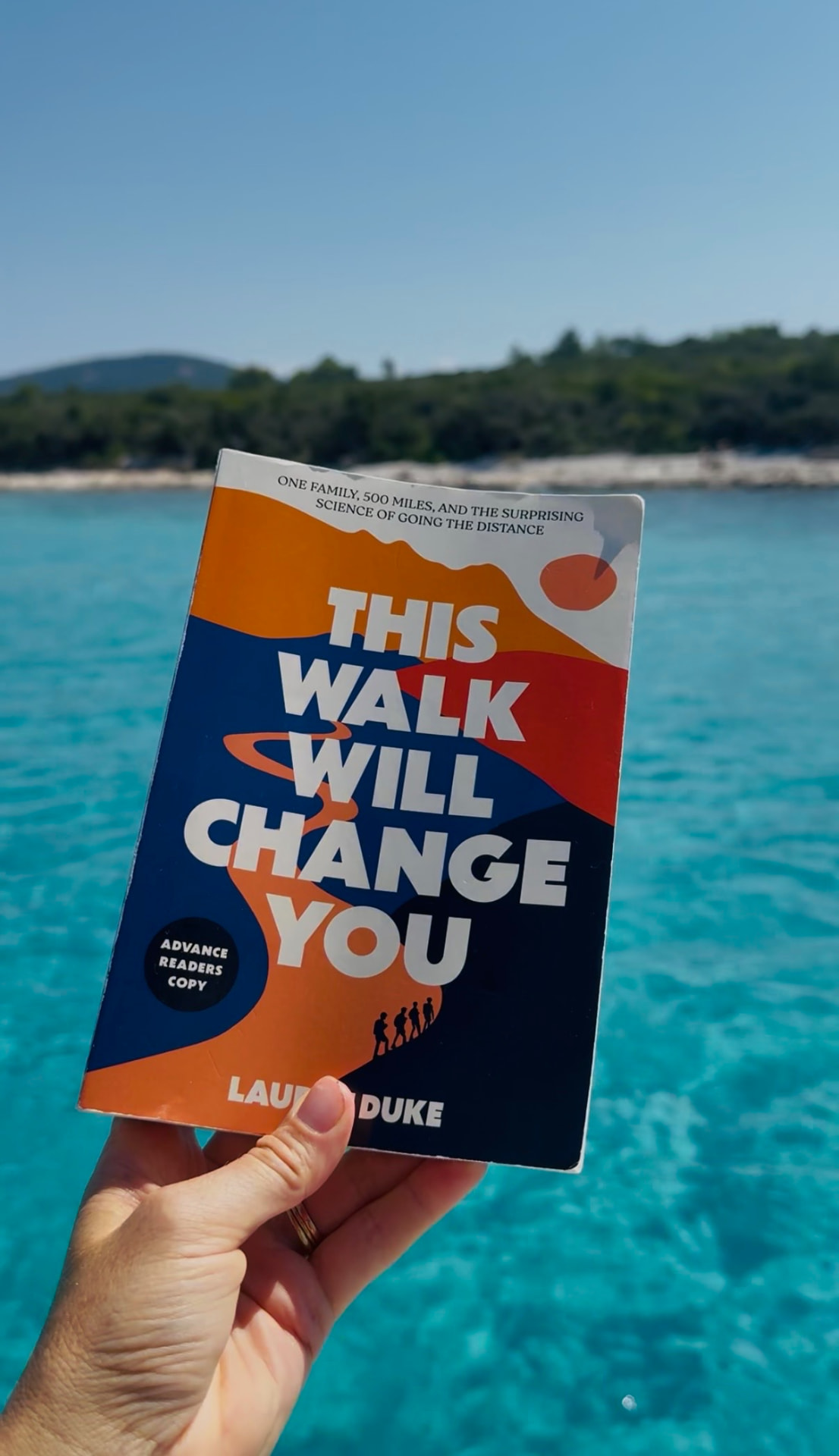 The book held above turquoise Adriatic water