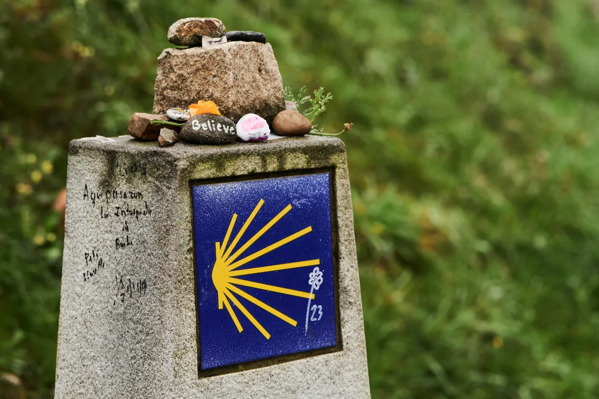 Camino de Santiago waymark stone with the yellow scallop shell
