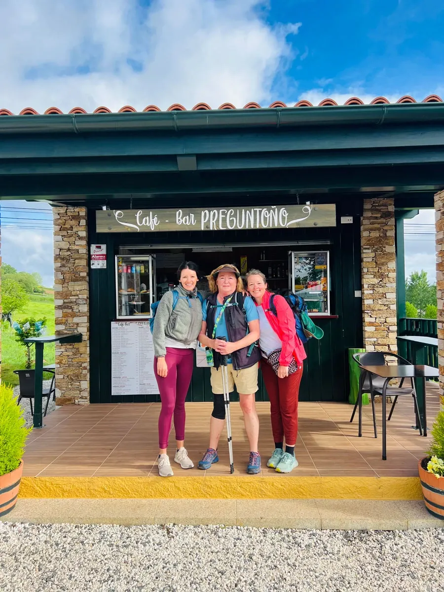Lauren Duke, her mother Mary, and her sister Leah outside a café on the Camino de Santiago, wearing packs