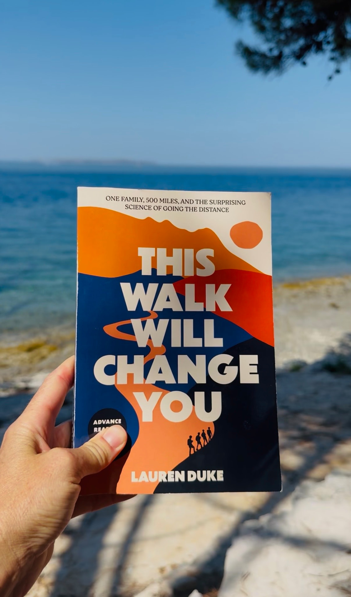 The book held at a rocky coastline overlook